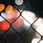 blurred city view beyond wire mesh fence / mesh network